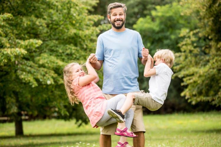 A father playing with his kids at a park