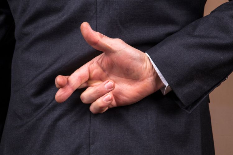 Fingers crossed behind a man's back