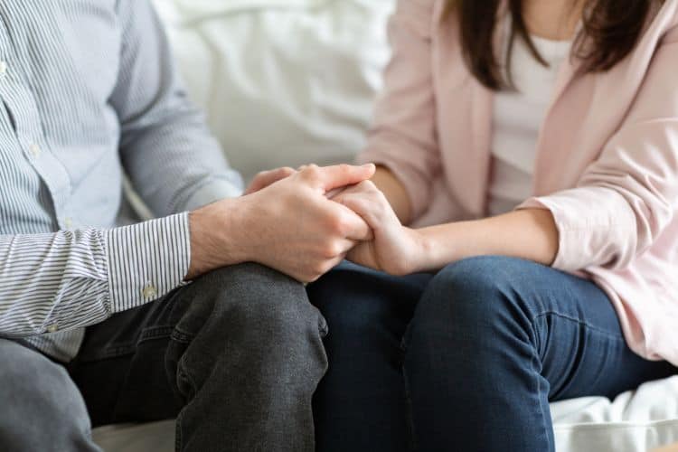 Married couple holding each others hands