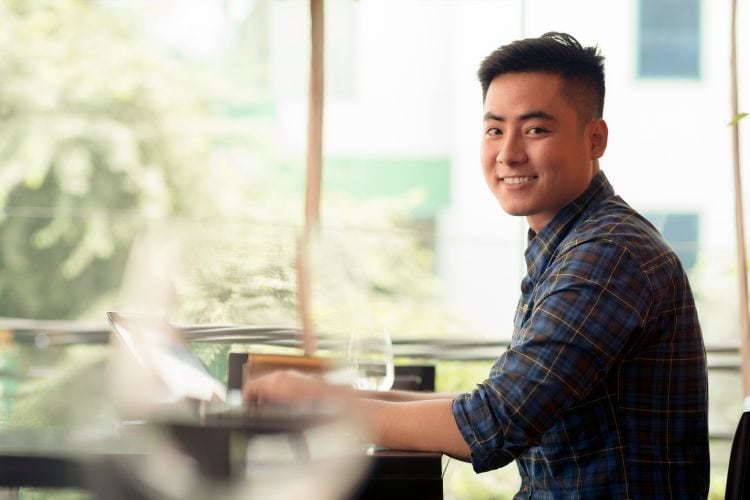 Smiling Man Working at a Cafe, Smiling at a Stranger