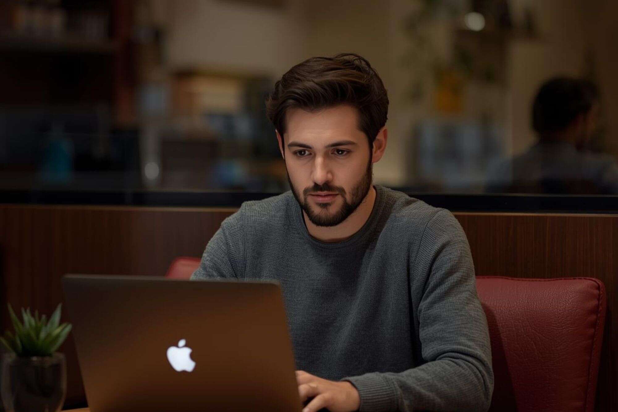 A man working independently on a laptop in a quiet environment, representing the Sigma male’s self-reliance and focus on personal growth.
