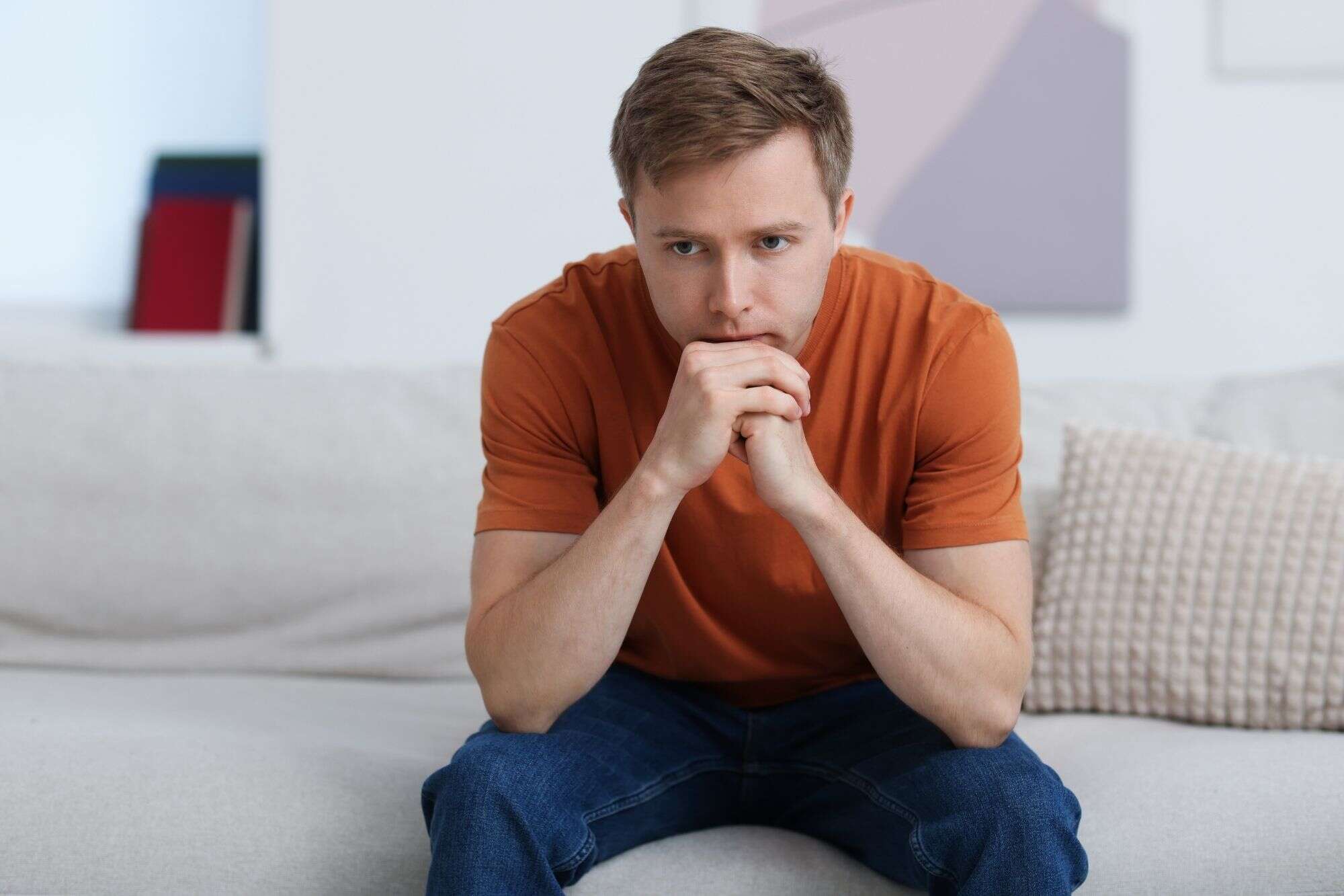 A man sitting looking tired and contemplative, reflecting the emotional drain of dating someone with an avoidant attachment style.
