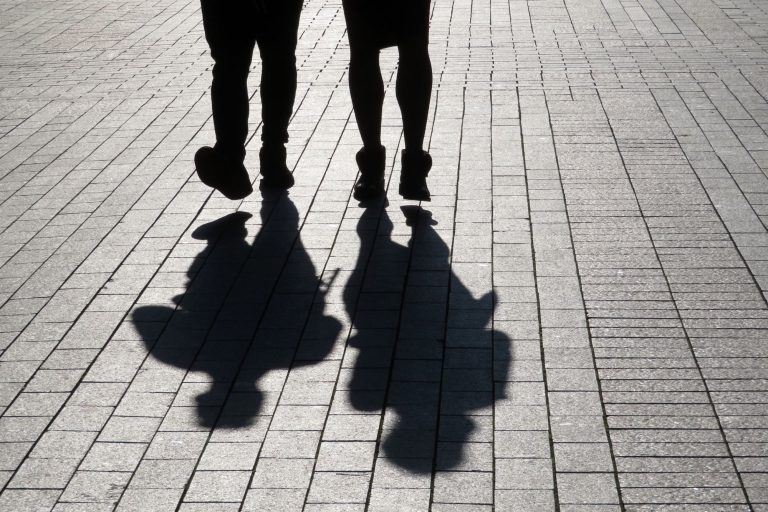 Two men walking together in a city.