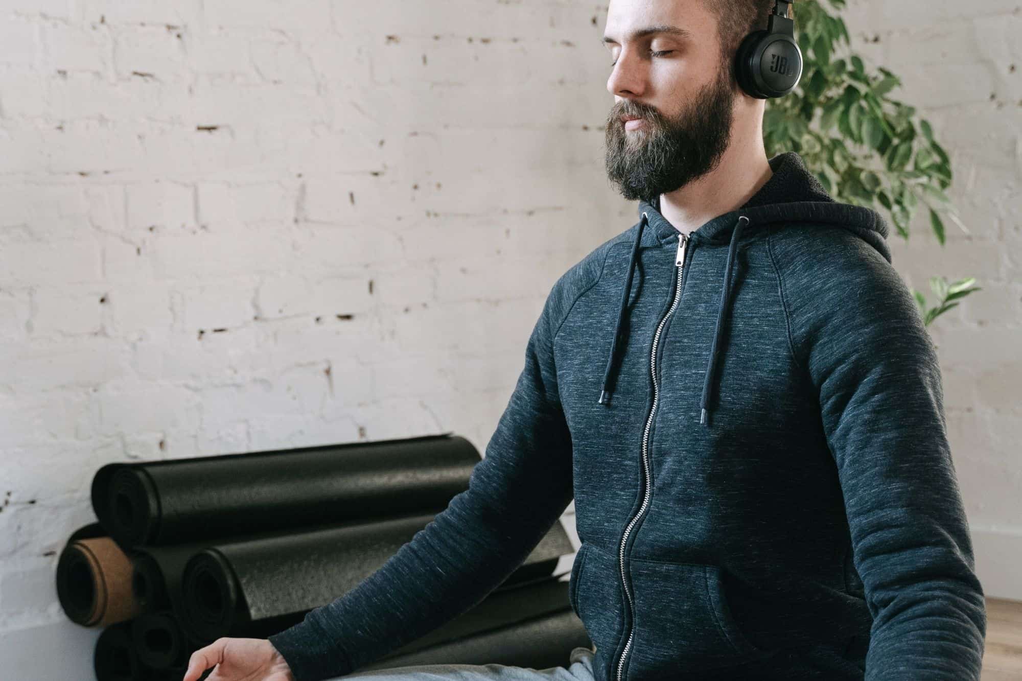 A man meditating calmly in a peaceful, minimalist home office, showing the importance of creating a supportive environment for highly sensitive nervous systems.
