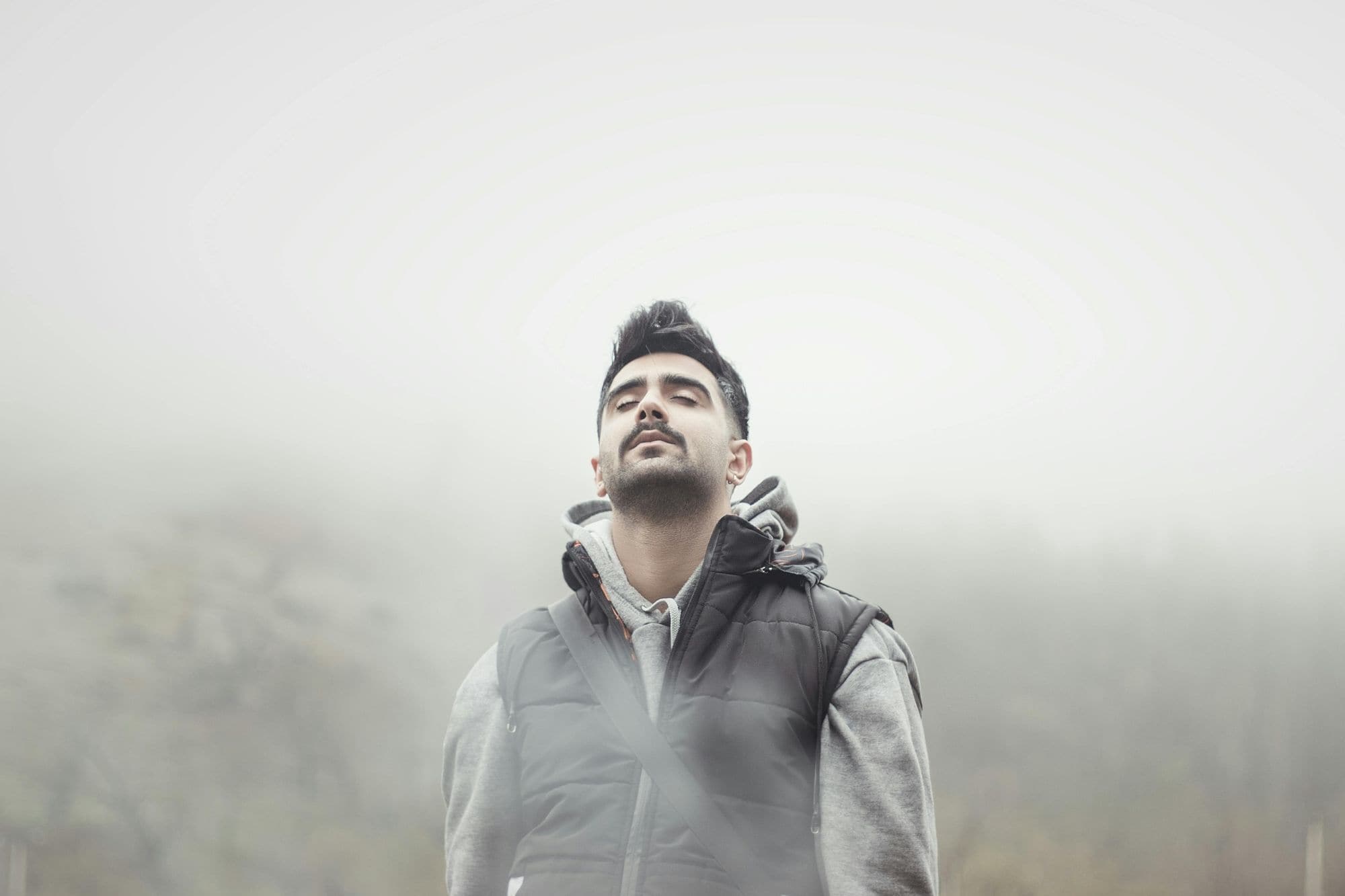A man in a simple, dark jacket looking calm and self-contained, representing the quiet strength of the zeta male archetype.