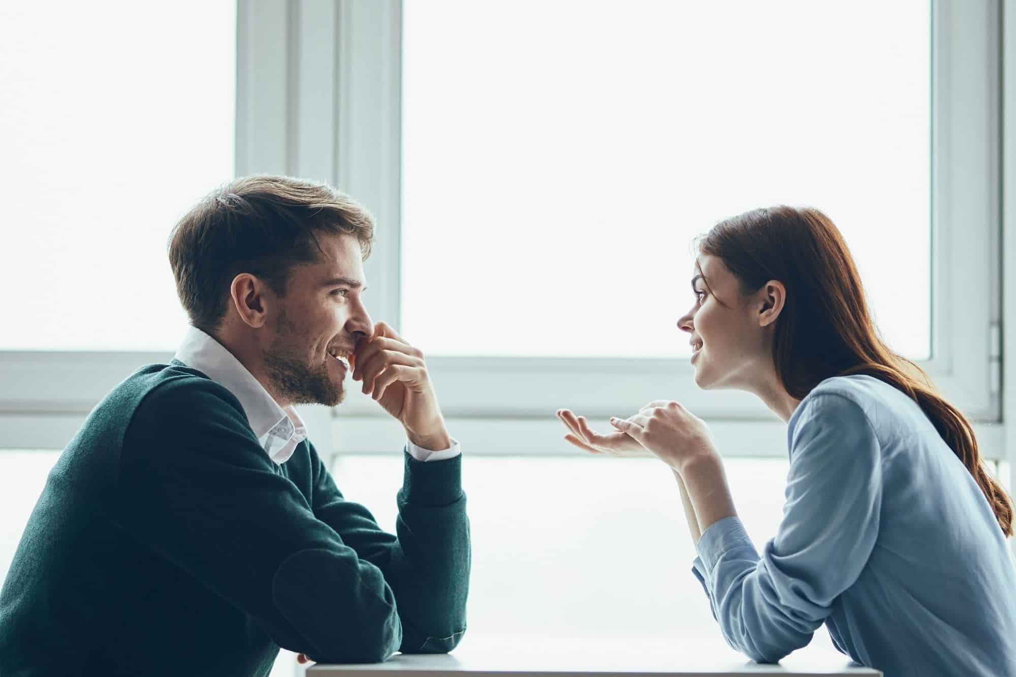 A man and woman sharing a grounded and focused conversation outdoors, showing the deep respect and attraction found in zeta male relationships.