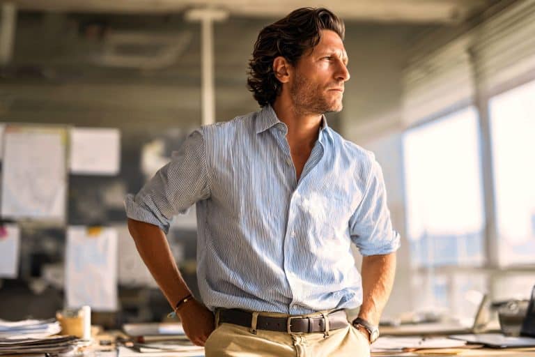 thoughtful, introspective man looking off-camera in an urban setting, representing the unique blend of independence and intuition of the Sigma empath male.