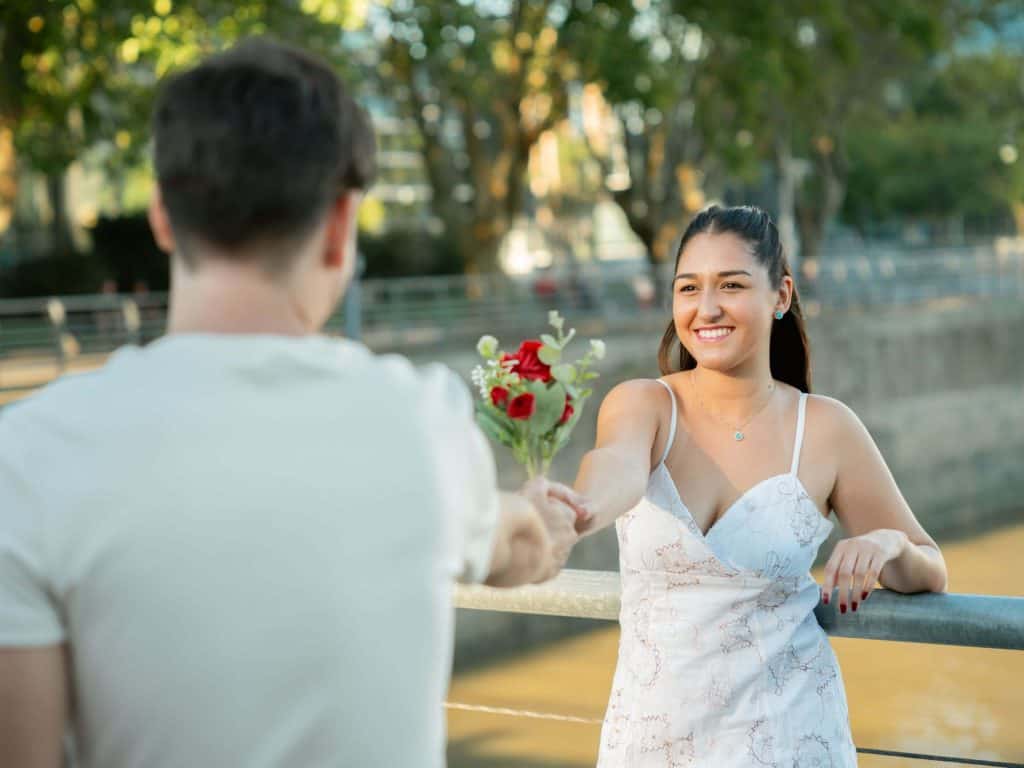 a man handing a woman flowers