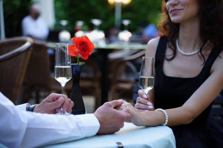 man and woman holding hands over a romantic setting of a table